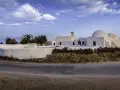Białe budynki z kopułami na Djerbie. Uważaj na słońce i upał, ale podziwiaj architekturę.
