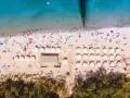 Plaża z parasolami i ludźmi, idealna na wakacje all inclusive Polska.