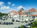 Elegancki hotel 5 gwiazdkowy nad morzem z przestronnym parkingiem i zielonym otoczeniem.