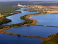 Widok z lotu ptaka na jezioro z wyspami, lasami i zabudowaniami w tle.