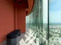 Wnętrze najwyższego budynku we Wrocławiu z ławką i panoramicznym widokiem na miasto przez zakrzywione okna.