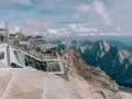 Tłum turystów na tarasie widokowym Zugspitze, najwyższego szczytu Niemiec, podziwia alpejskie krajobrazy.