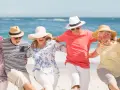 Szczęśliwi seniorzy na plaży, cieszący się słońcem i morzem. Idealne wczasy dla seniora 7 dniowe, pełne radości i wspólnych chwil.