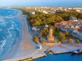 Widok na nadmorskie miasteczko z latarnią morską i plażą. Idealne miejsce na wakacje dla singli, pełne słońca i morskiej bryzy.