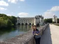 Kobieta na moście przed zamkiem Chenonceau, nad rzeką Cher, dopływem najdłuższej rzeki Francji, Loary.
