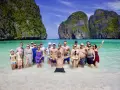 Grupa ludzi cieszy się słońcem i turkusową wodą na plaży Maya Bay.
