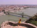 Widok na Dunaj w Budapeszcie z zielonym mostem i kobietą w żółtej sukience.