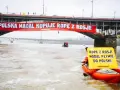 Na moście Poniatowskiego wisi czerwony baner "Polska nadal kupuje ropę z Rosji!". Kajakarz Greenpeace na Wiśle trzyma żółtą tablicę "Ropa z Rosji nadal płynie do Polski".