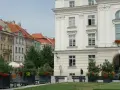 Urokliwe miasto nad Prosną z zabytkową architekturą, zielenią i ławkami w centrum.