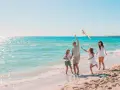Rodzina puszcza latawiec na plaży. Idealne fajne miejsce na wakacje z dzieckiem w Polsce.