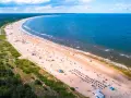 Szeroka, piaszczysta plaża z tłumem turystów, zielony las i błękitne morze – to jedne z najpiękniejszych plaż w Polsce.