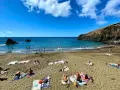 Słoneczne madera plaże z turystami kąpiącymi się w turkusowym oceanie i opalającymi się na piasku.