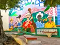 Kolorowy mural przedstawia muzyków grających na instrumentach, jakby na ulicy stolicy Kuby.