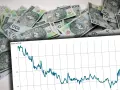 Stos 100-złotowych banknotów, symbol najdroższej waluty, na tle wykresu ceny w PLN.