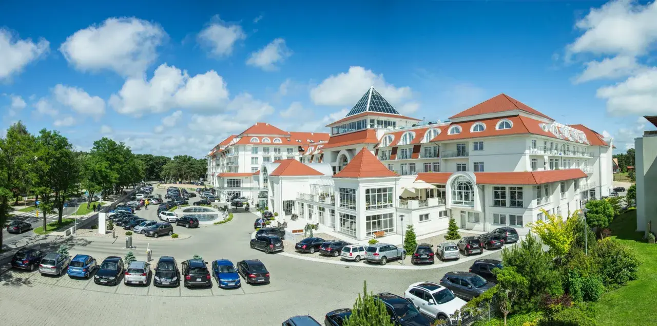 Elegancki hotel 5 gwiazdkowy nad morzem z przestronnym parkingiem i zielonym otoczeniem.