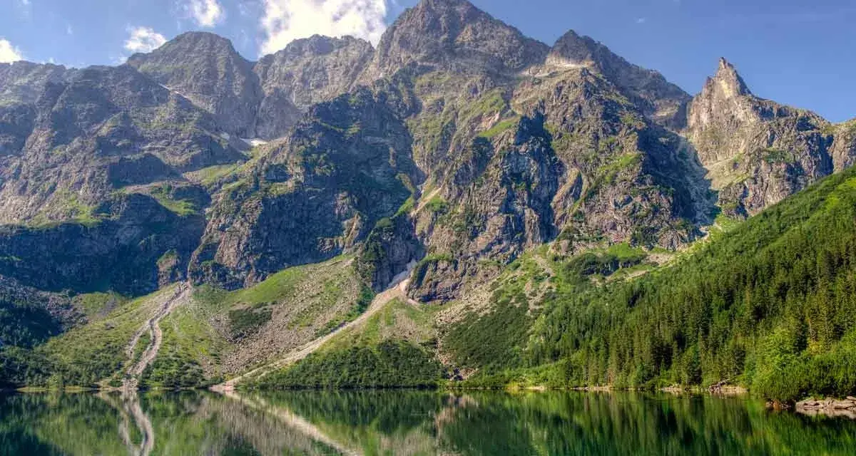 Majestatyczne, skaliste szczyty Tatr, najwyższe góry w Polsce, odbijają się w spokojnej tafli jeziora Morskie Oko.