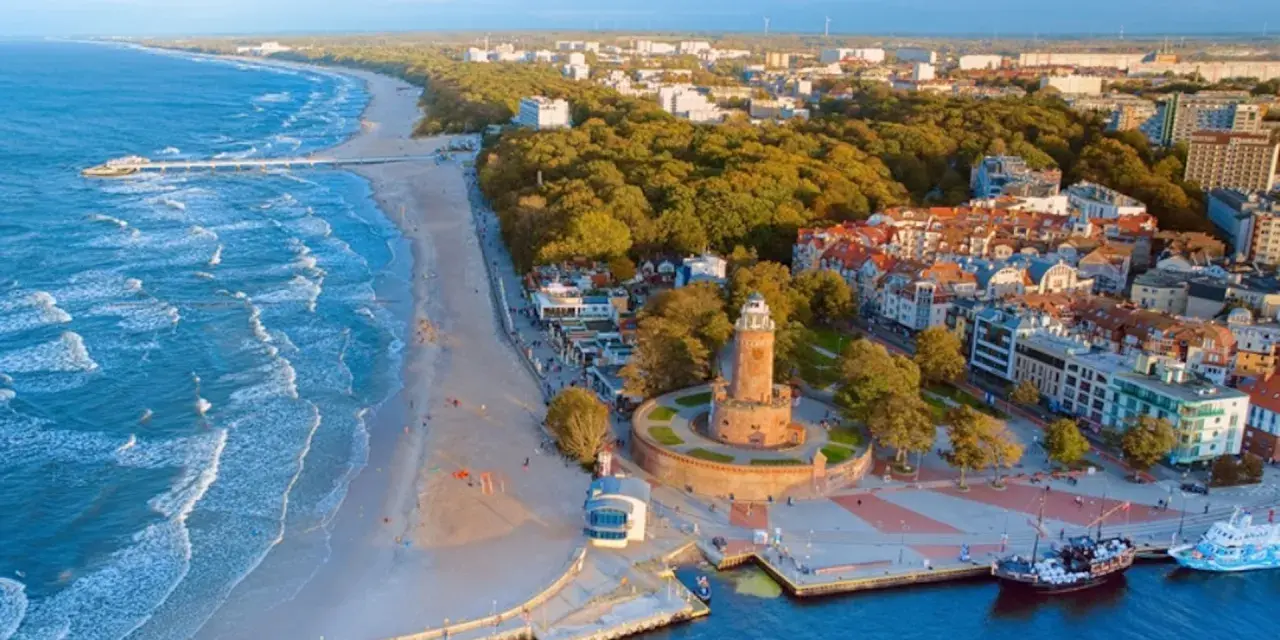 Widok na nadmorskie miasteczko z latarnią morską i plażą. Idealne miejsce na wakacje dla singli, pełne słońca i morskiej bryzy.