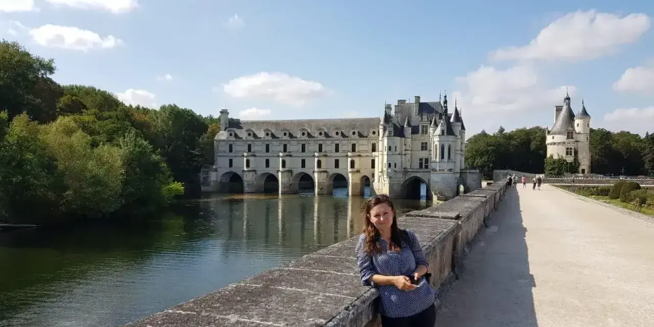 Kobieta na moście przed zamkiem Chenonceau, nad rzeką Cher, dopływem najdłuższej rzeki Francji, Loary.