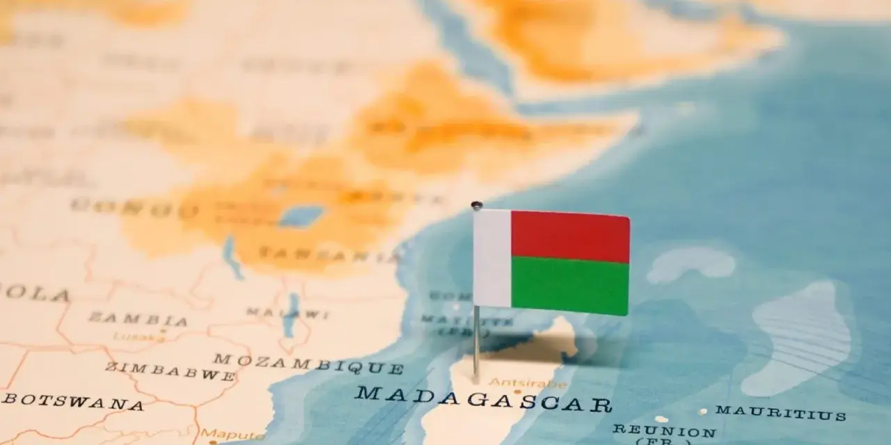 Flaga Madagaskaru na mapie. Widoczna jest Afryka i wyspa, gdzie leży Madagaskar, obok Mozambiku.
