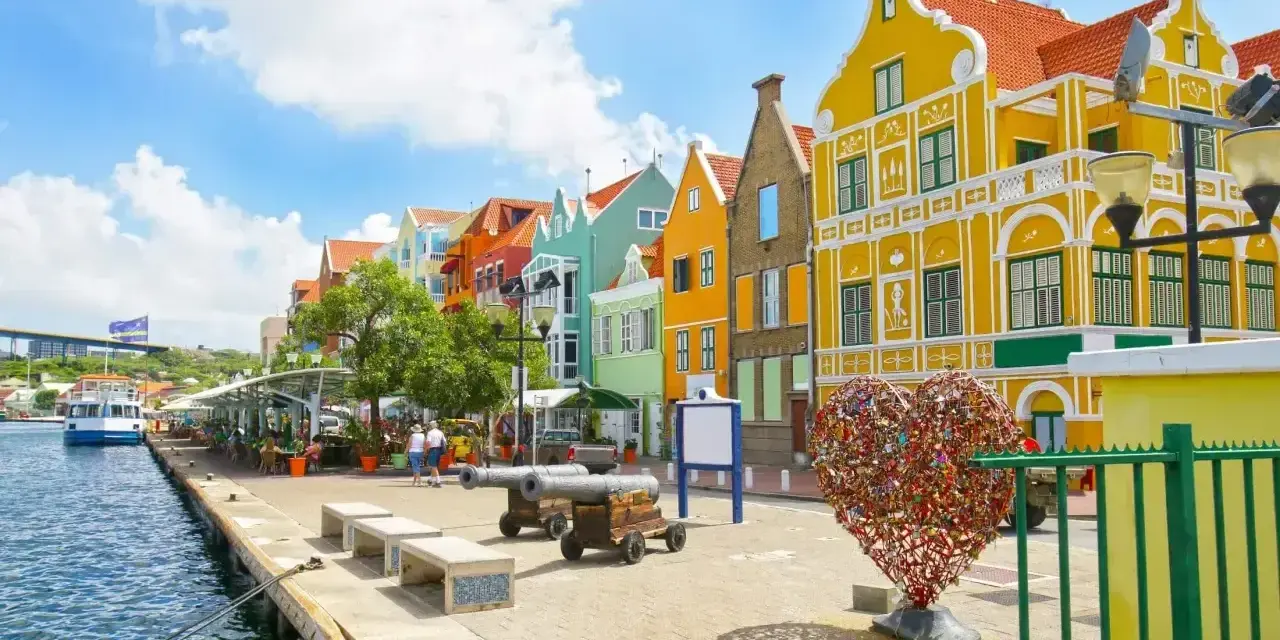 Kolorowe budynki, port i serce z kłódek – idealne miejsce na curacao wakacje.