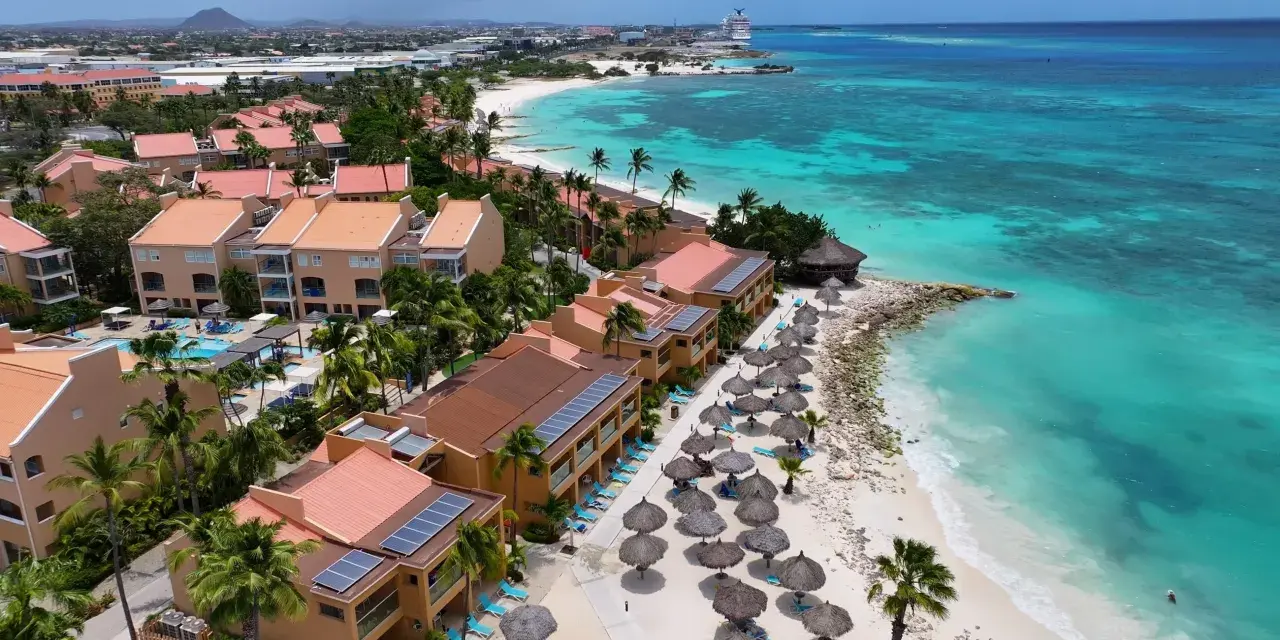 Aruba, gdzie jest? Tropikalny raj z turkusową wodą, piaszczystą plażą, palmami i hotelami z czerwonymi dachami.