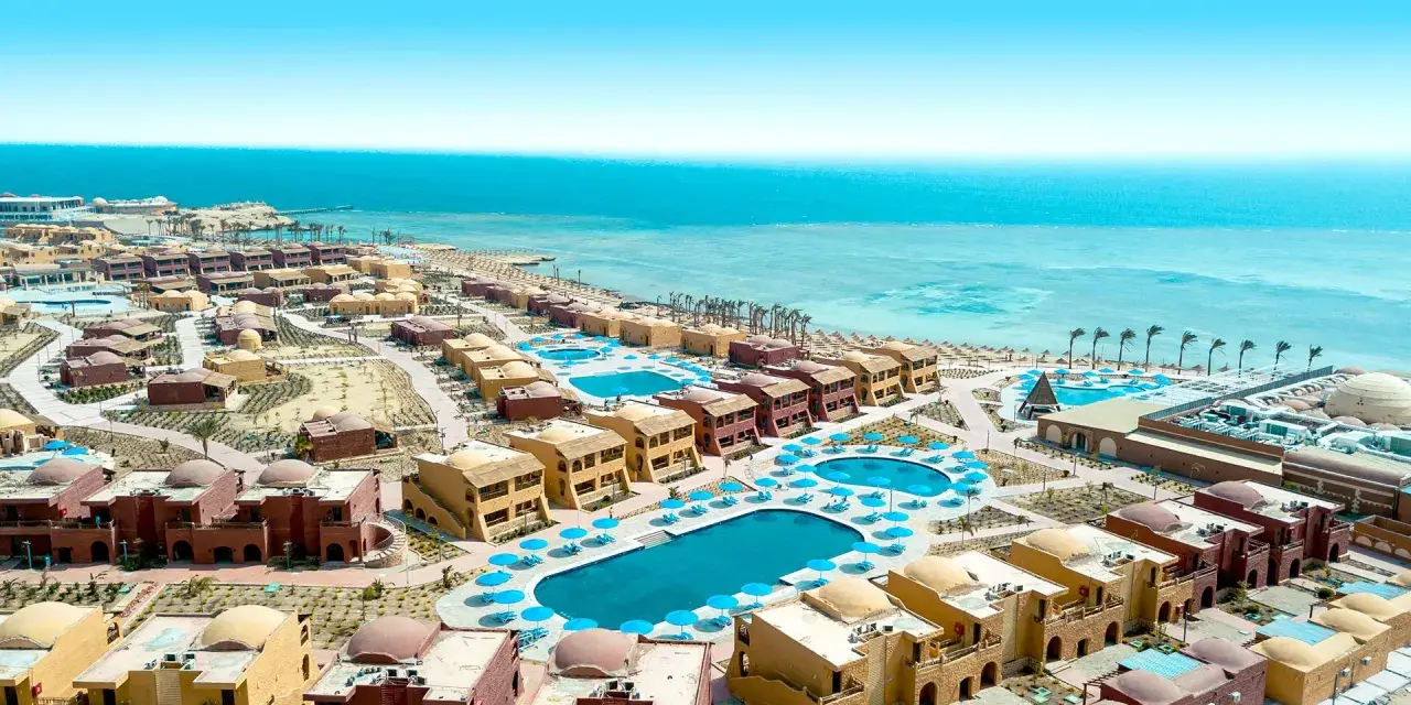 Widok z lotu ptaka na kompleks hotelowy Pickalbatros Marsa Alam z basenami i budynkami w stylu orientalnym, w tle turkusowe Morze Czerwone.