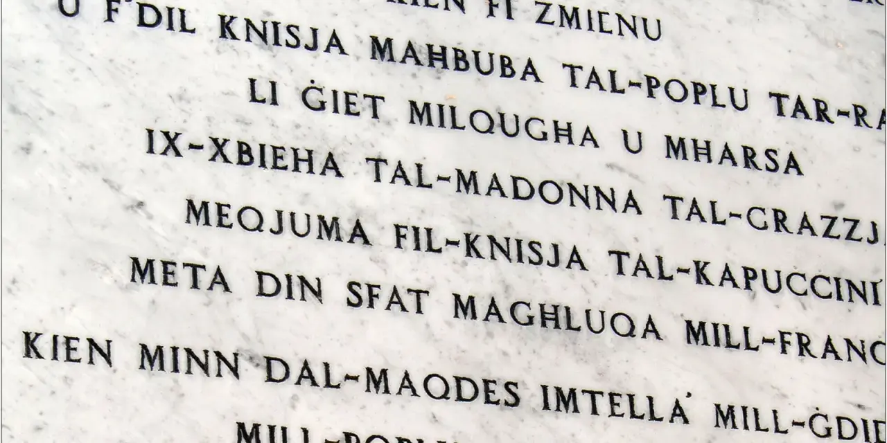 Napis na marmurze w języku maltańskim. Tekst opowiada historię o kościele i jego znaczeniu dla ludzi.