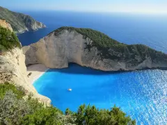 Grecja gdzie na wakacje? Zatoka Wraku na Zakynthos, z turkusową wodą i klifami, idealne miejsce na niezapomniany urlop.