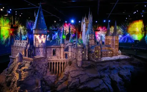Model zamku Hogwart w muzeum Harry'ego Pottera, oświetlony magicznymi projekcjami i fajerwerkami.