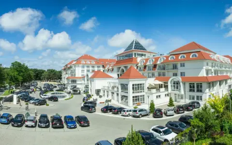 Elegancki hotel 5 gwiazdkowy nad morzem z przestronnym parkingiem i zielonym otoczeniem.
