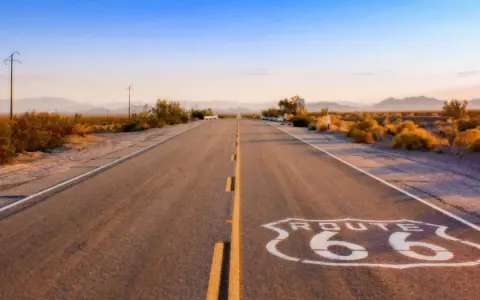 Droga Route 66 w pustynnym krajobrazie o zachodzie słońca.