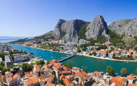 Widok na miasto Omiš w Chorwacji, gdzie rzeka Cetina wpada do morza. Piękne, turkusowe morze i góry.