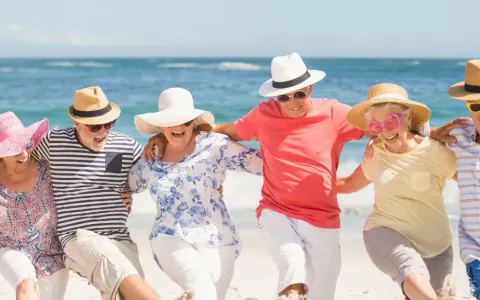 Szczęśliwi seniorzy na plaży, cieszący się słońcem i morzem. Idealne wczasy dla seniora 7 dniowe, pełne radości i wspólnych chwil.