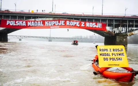 Na moście Poniatowskiego wisi czerwony baner "Polska nadal kupuje ropę z Rosji!". Kajakarz Greenpeace na Wiśle trzyma żółtą tablicę "Ropa z Rosji nadal płynie do Polski".
