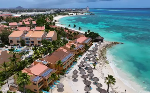 Aruba, gdzie jest? Tropikalny raj z turkusową wodą, piaszczystą plażą, palmami i hotelami z czerwonymi dachami.