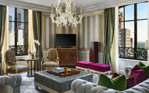 Luksusowy salon z widokiem na miasto, gdzie każdy detal krzyczy "najdroższy hotel na świecie".