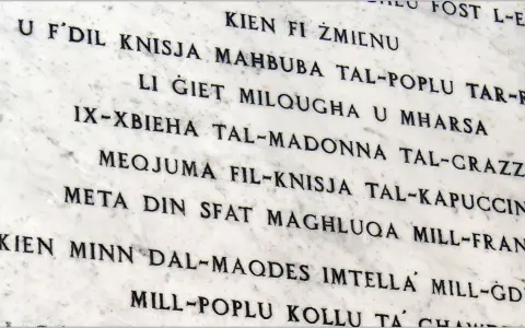 Napis na marmurze w języku maltańskim. Tekst opowiada historię o kościele i jego znaczeniu dla ludzi.