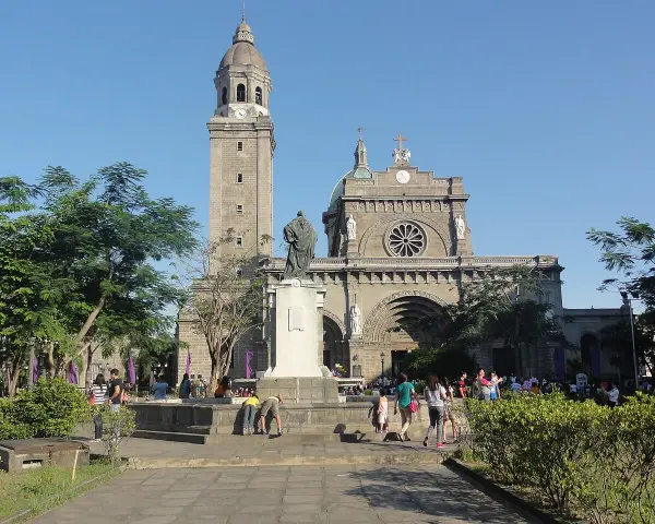 Manila Cathedral, symbol Filipiń religia. Ludzie spacerują przed monumentalną budowlą, podziwiając architekturę i atmosferę.