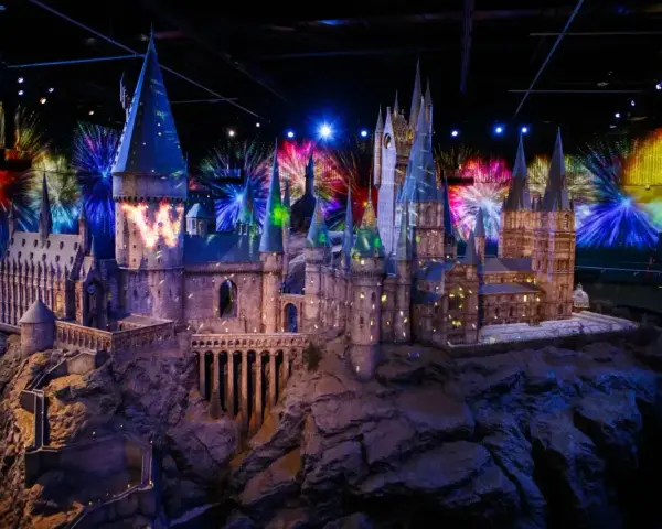 Model zamku Hogwart w muzeum Harry'ego Pottera, oświetlony magicznymi projekcjami i fajerwerkami.