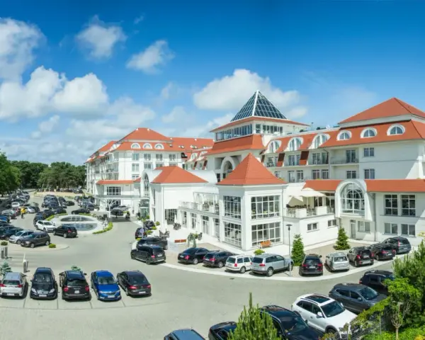 Elegancki hotel 5 gwiazdkowy nad morzem z przestronnym parkingiem i zielonym otoczeniem.