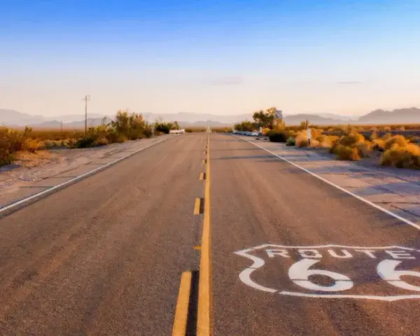 Droga Route 66 w pustynnym krajobrazie o zachodzie słońca.