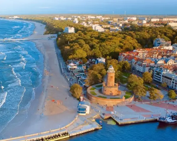 Widok na nadmorskie miasteczko z latarnią morską i plażą. Idealne miejsce na wakacje dla singli, pełne słońca i morskiej bryzy.