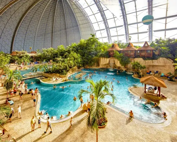 Wielki tropikalny basen pod kopułą, z palmami, wodospadami i domkami. Sprawdź nasz tropical island cennik, by zaplanować wakacje!