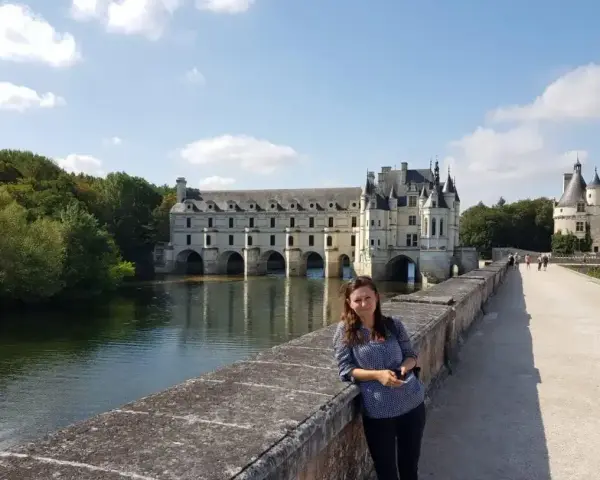 Kobieta na moście przed zamkiem Chenonceau, nad rzeką Cher, dopływem najdłuższej rzeki Francji, Loary.