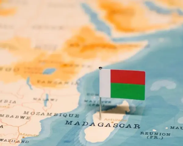 Flaga Madagaskaru na mapie. Widoczna jest Afryka i wyspa, gdzie leży Madagaskar, obok Mozambiku.