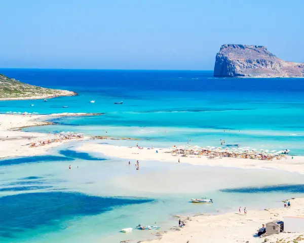 Piękna plaża z turkusową wodą i skalistą wysepką. Czy to Rodos czy Kreta?