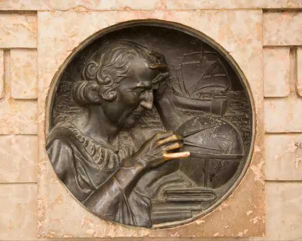 Krzysztof Kolumb, badający mapy i globus, symbolizuje jego pochodzenie i dążenie do odkryć. W tle żaglowiec.