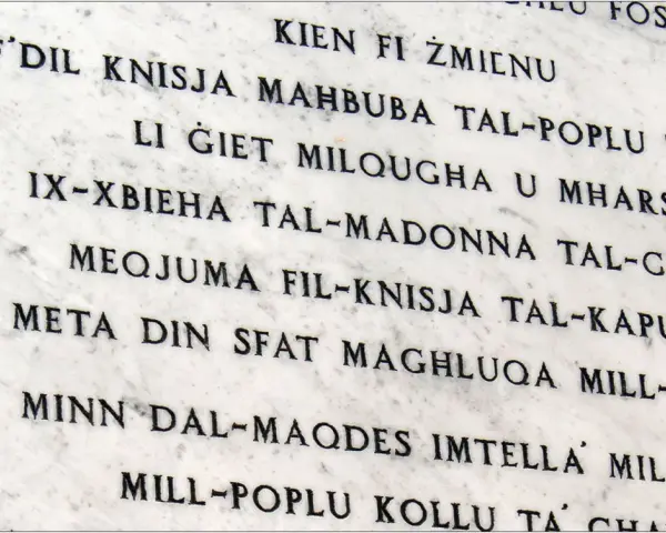 Napis na marmurze w języku maltańskim. Tekst opowiada historię o kościele i jego znaczeniu dla ludzi.