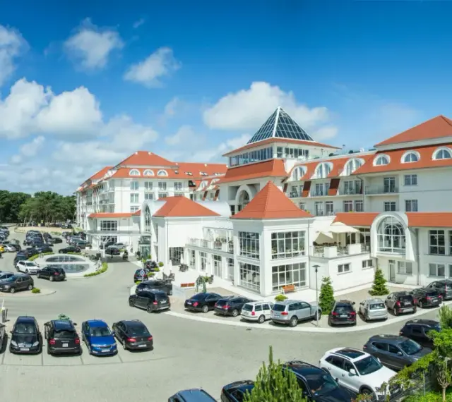 Elegancki hotel 5 gwiazdkowy nad morzem z przestronnym parkingiem i zielonym otoczeniem.