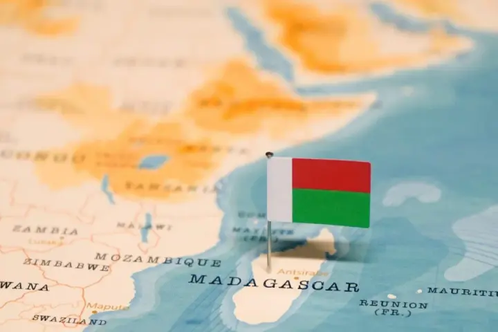 Flaga Madagaskaru na mapie. Widoczna jest Afryka i wyspa, gdzie leży Madagaskar, obok Mozambiku.